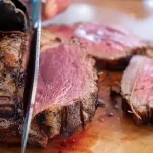 Appetizing close-up of a succulent sliced roast beef with a knife.
